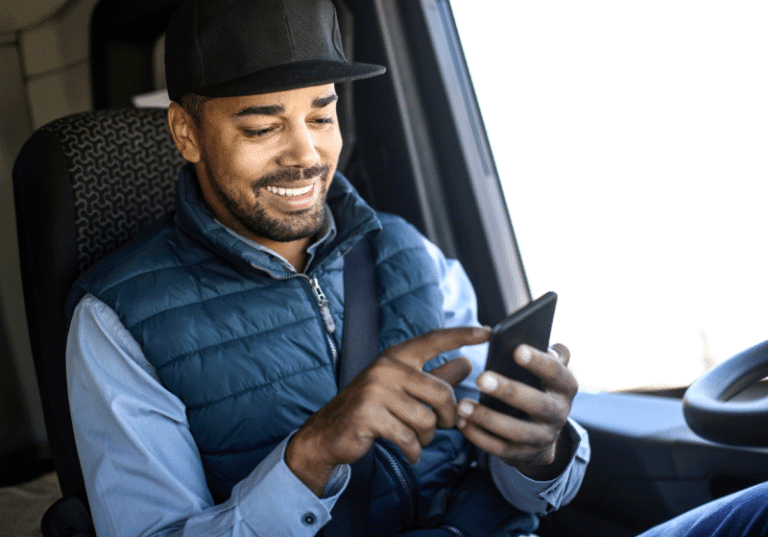 man on his phone in the cab of a truck