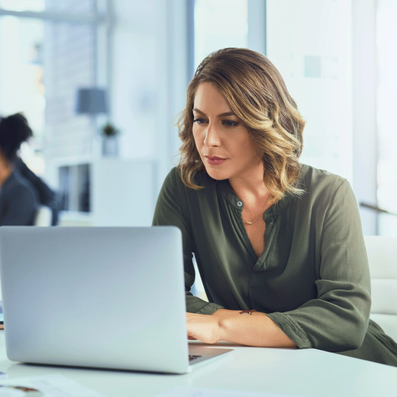 Woman focusing, staring at laptop.