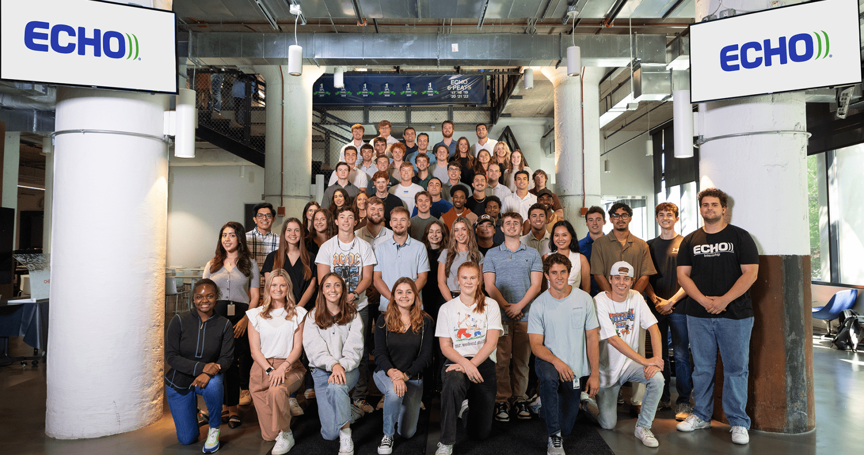 A group photo of an Echo internship class standing on Echo's entryway steps.