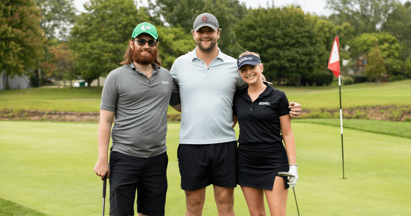 Three Echo employees smiling for a picture at Echo's annual golf outing.
