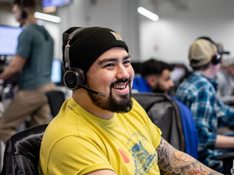 An Echo employee sitting at their workstation with a headset on to answer client calls.