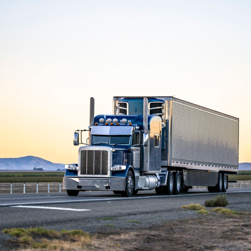 Large blue semi truck driving down California highway.