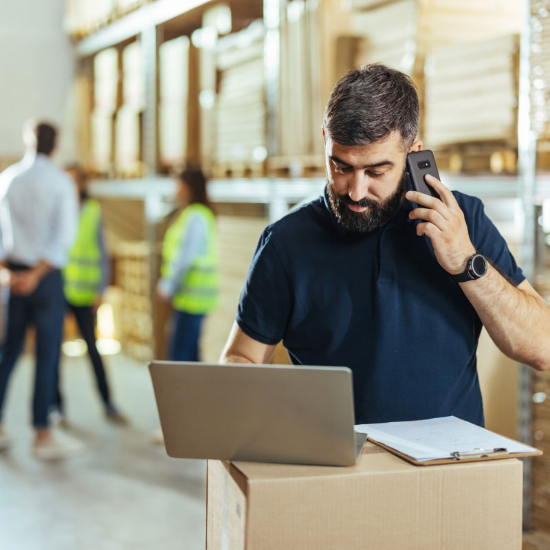 Man on phone working in warehouse.