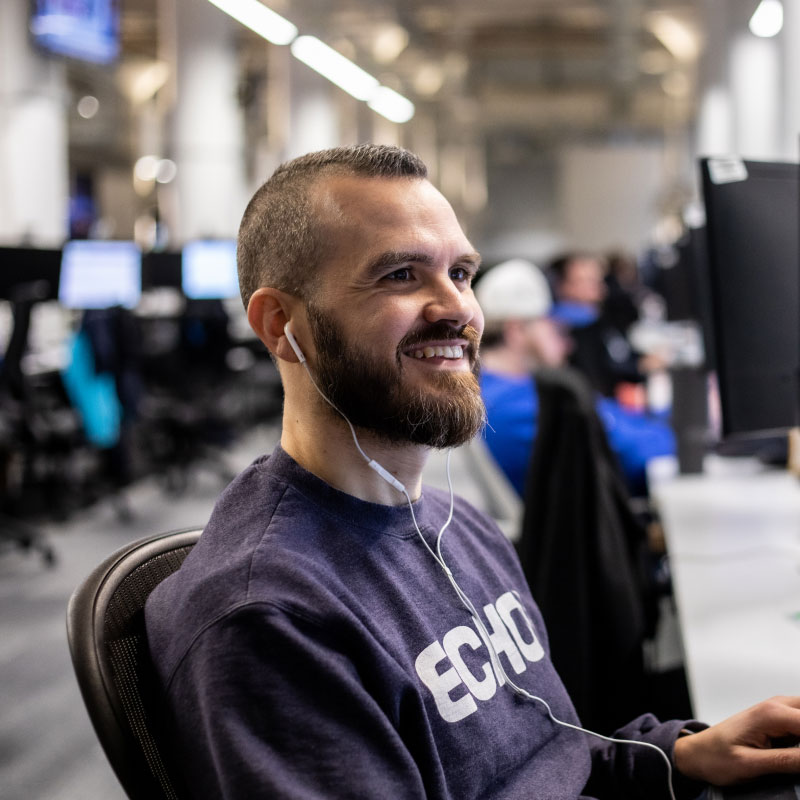 An Echo employee smiling while working at their computer.