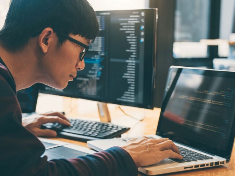 A man working on coding a program on his computer.