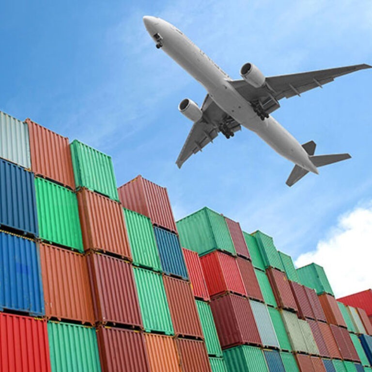 A plane flying over several shipping containers transporting cargo to it's final destination.