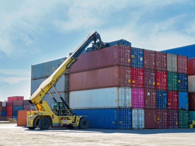 Forklift handling and moving shipping containers.