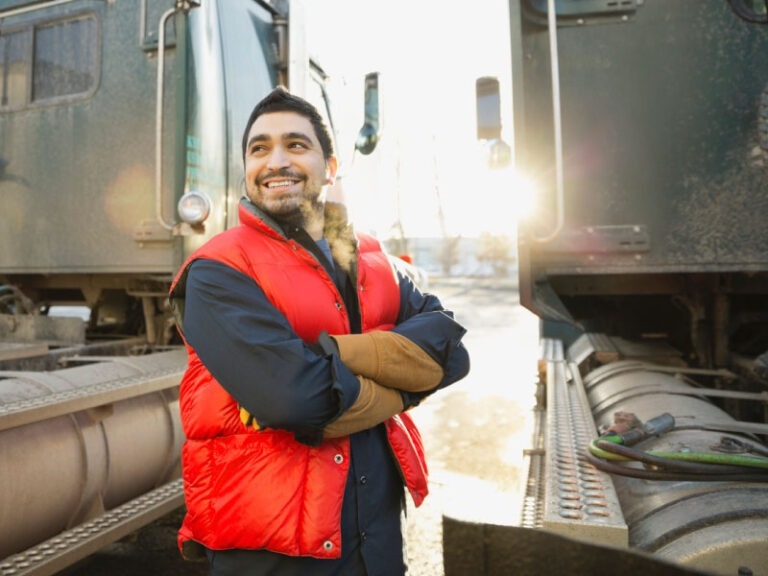 A smiling man standing outside of his truck