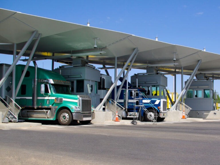 Semi-trucks at a paybooth at the Canadian border.