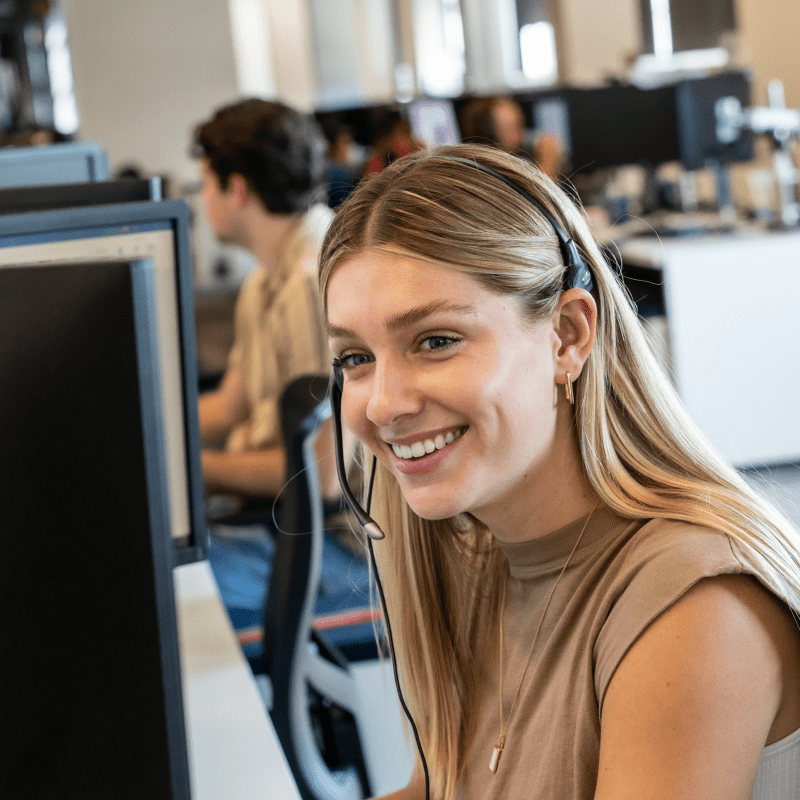 An Echo employee smiling while working on their computer at their desk.