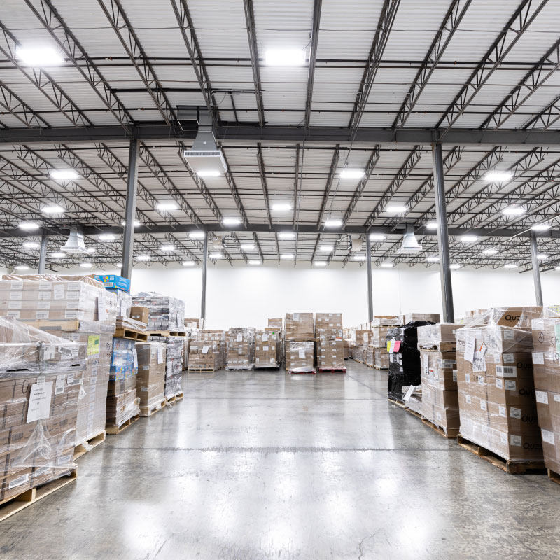 A well lit warehousing facility with multiple boxes wrapped up.