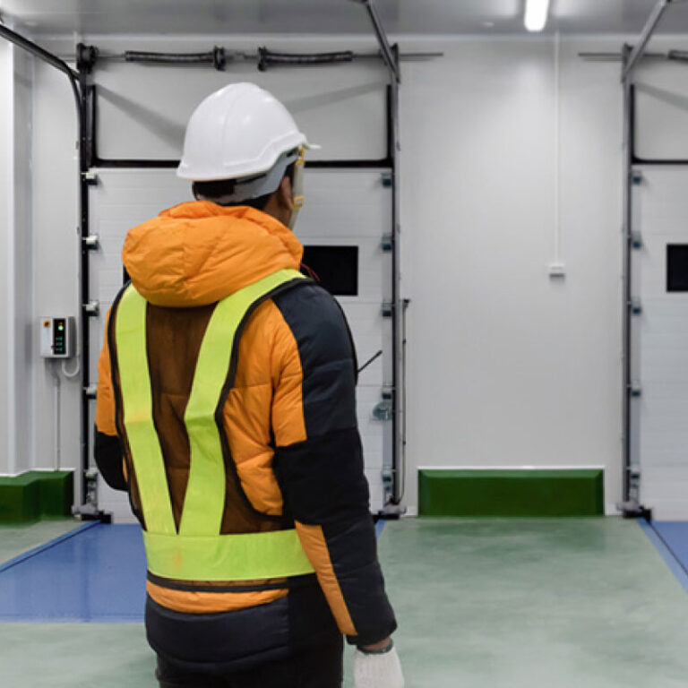Two warehousing experts in a temperature controlled warehouse environment.