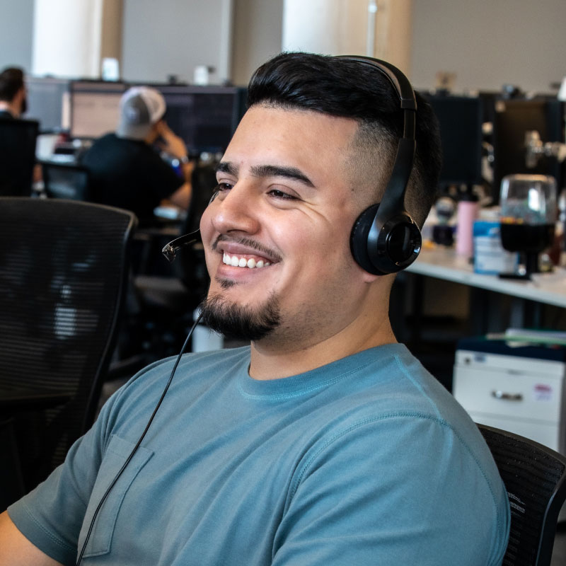 Echo employee working at desktop smiling and answering calls.