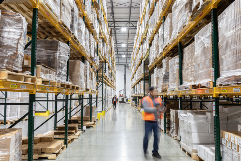 Warehouse workers checking and organizing shipment storage in a FDA warehouse facility.