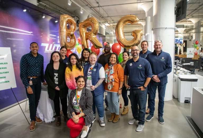 A group of Echo's BRG leaders posing in front of balloons that spell out BRG during their BRG fair. 