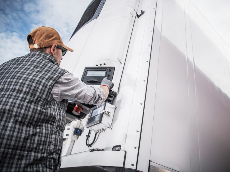 A truck driver adjusts the temperature of their refrigeration semi truck trailer.