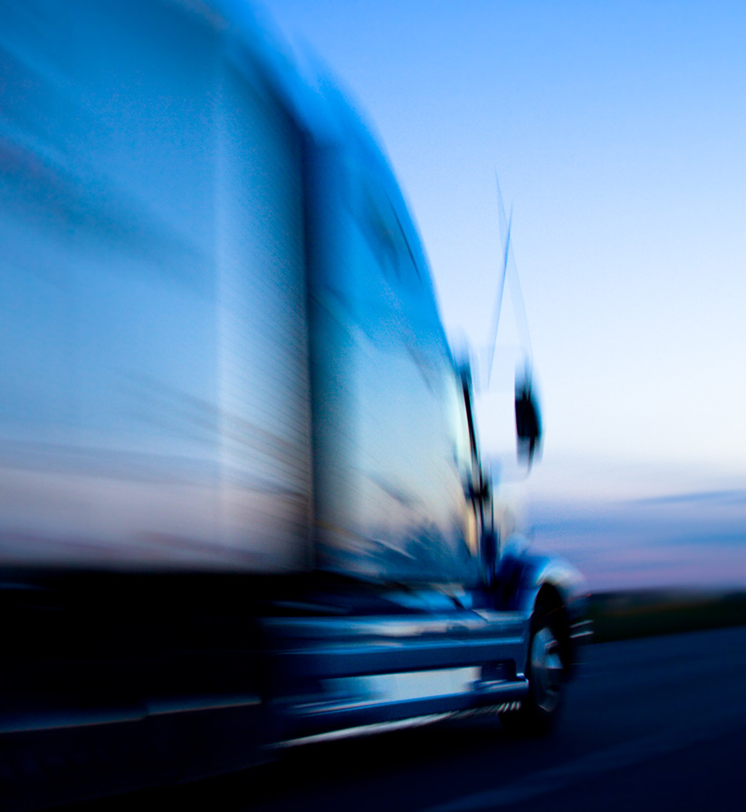 Blue semi truck speeding down the highway for same day delivery.